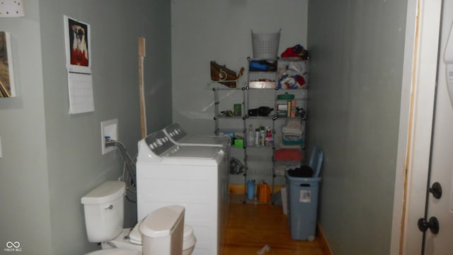 bathroom featuring hardwood / wood-style floors, toilet, and washing machine and clothes dryer