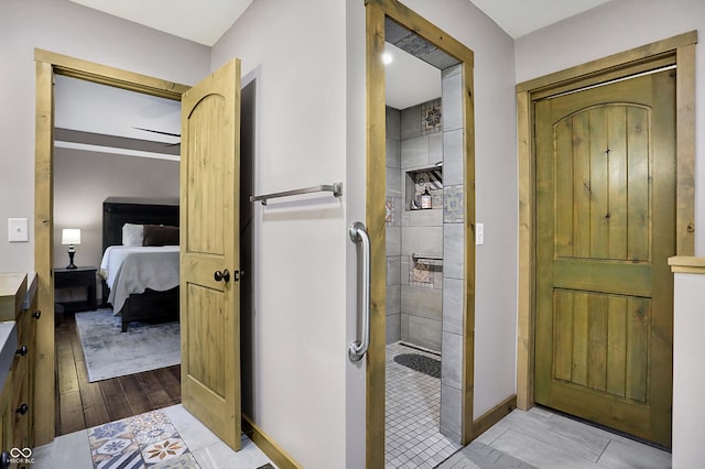 bathroom with vanity, tiled shower, and hardwood / wood-style floors