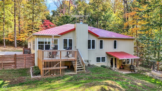 rear view of property featuring a patio, a deck, and a lawn