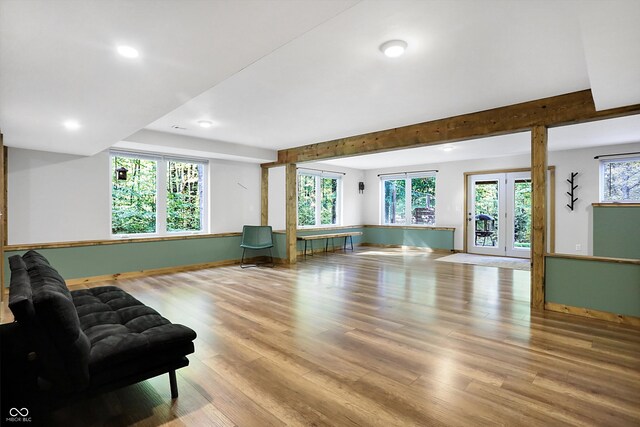 living room with french doors, light hardwood / wood-style flooring, and a wealth of natural light