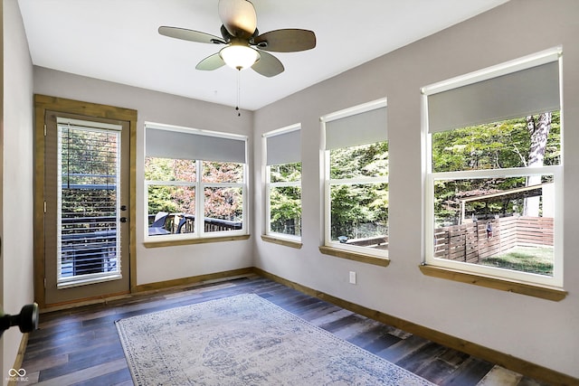 unfurnished sunroom featuring ceiling fan and a healthy amount of sunlight