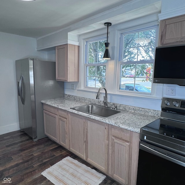 kitchen featuring appliances with stainless steel finishes, hanging light fixtures, sink, and light brown cabinetry