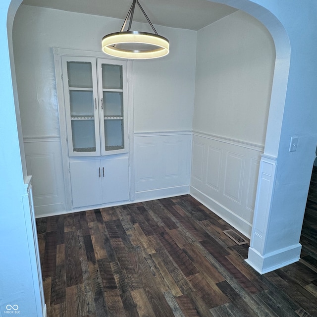 unfurnished dining area with dark wood-type flooring