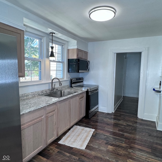 kitchen featuring dark hardwood / wood-style flooring, appliances with stainless steel finishes, light brown cabinetry, pendant lighting, and sink