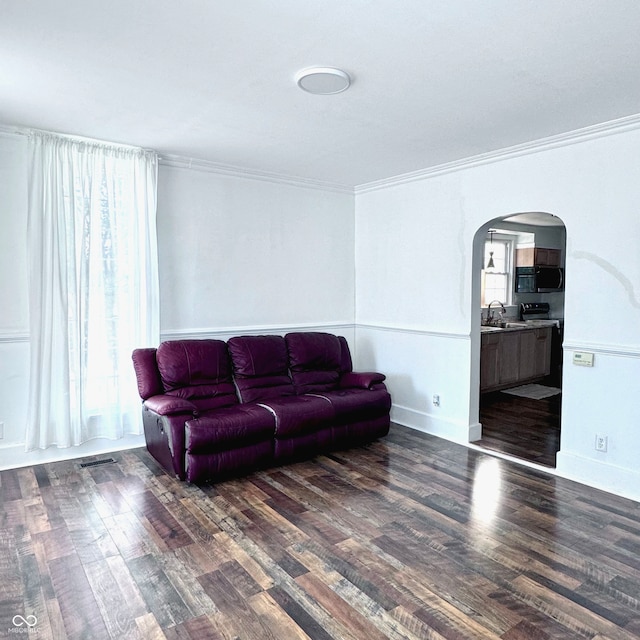 living room with ornamental molding, sink, and dark hardwood / wood-style floors