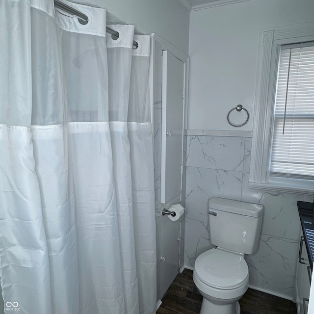 bathroom with tile walls, hardwood / wood-style floors, a shower with curtain, and toilet