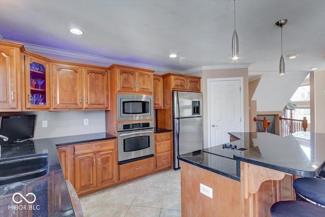 kitchen with brown cabinets, ornamental molding, decorative light fixtures, a kitchen bar, and appliances with stainless steel finishes