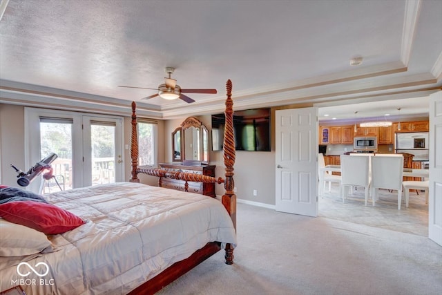 carpeted bedroom with ornamental molding, access to outside, ceiling fan, and a tray ceiling