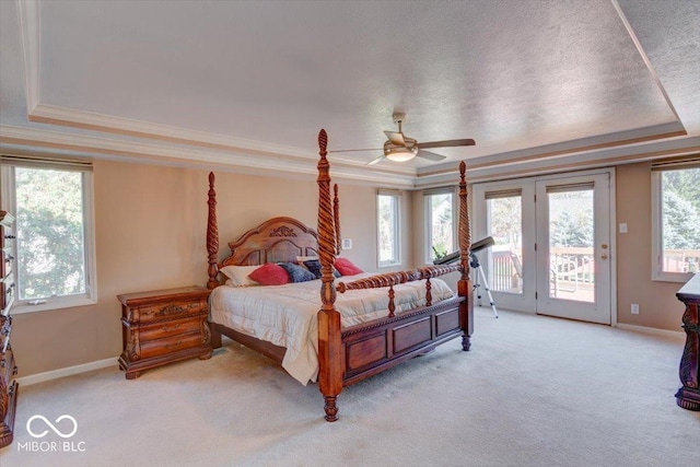 bedroom featuring light carpet, access to outside, a raised ceiling, and crown molding