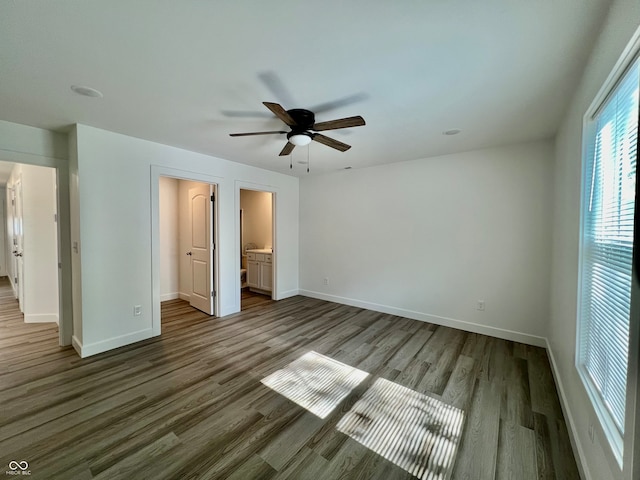 unfurnished bedroom with hardwood / wood-style floors, ensuite bath, and ceiling fan