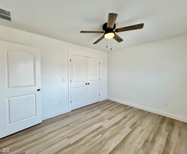 unfurnished bedroom featuring ceiling fan, light wood-type flooring, and a closet