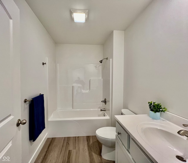 full bathroom with hardwood / wood-style floors, vanity, shower / bath combination, and toilet