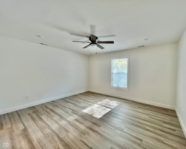 empty room with ceiling fan and light hardwood / wood-style flooring