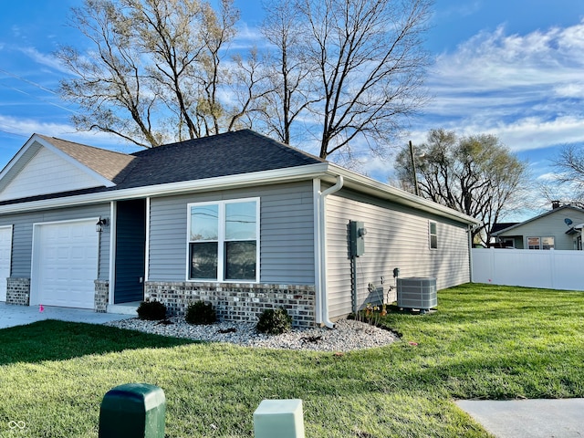 view of front of property with cooling unit, a front yard, and a garage