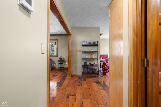 corridor featuring hardwood / wood-style floors and a textured ceiling