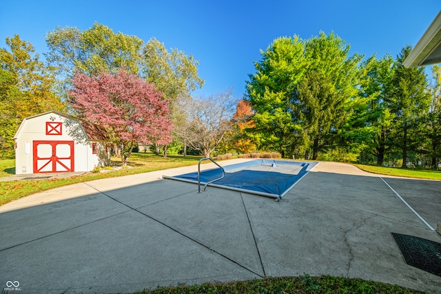 view of pool featuring a yard and a storage unit