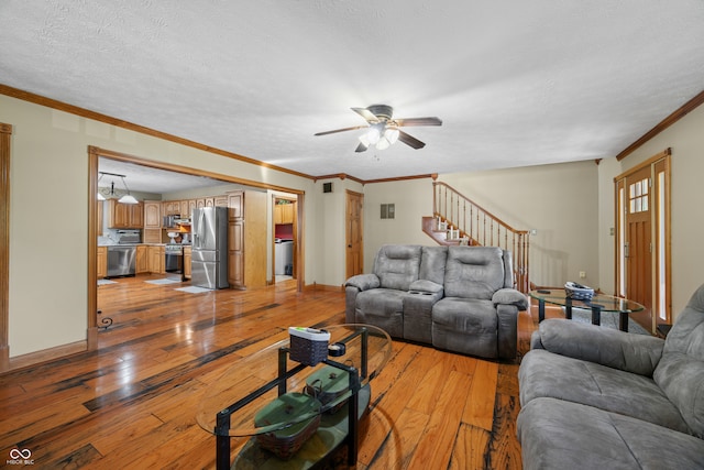 living room with light hardwood / wood-style floors, crown molding, a textured ceiling, and ceiling fan