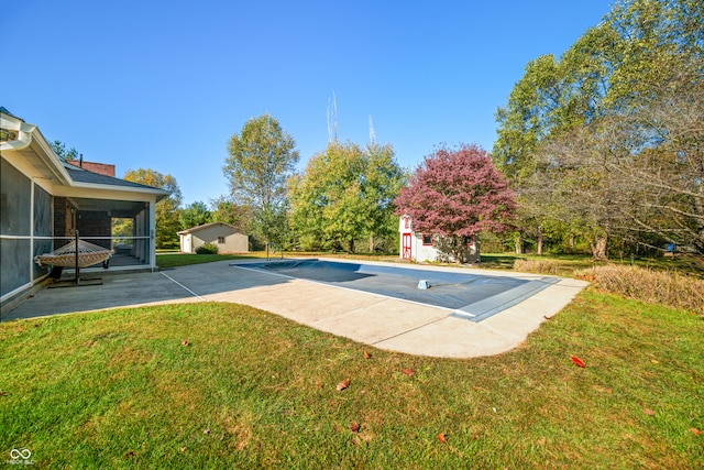 view of swimming pool with an outbuilding, a sunroom, and a lawn