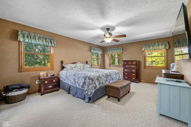 carpeted bedroom with a textured ceiling and ceiling fan