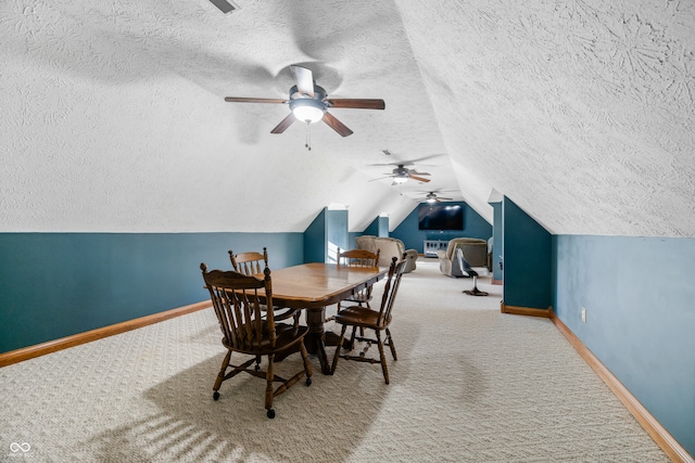 dining area with carpet flooring, a textured ceiling, vaulted ceiling, and ceiling fan