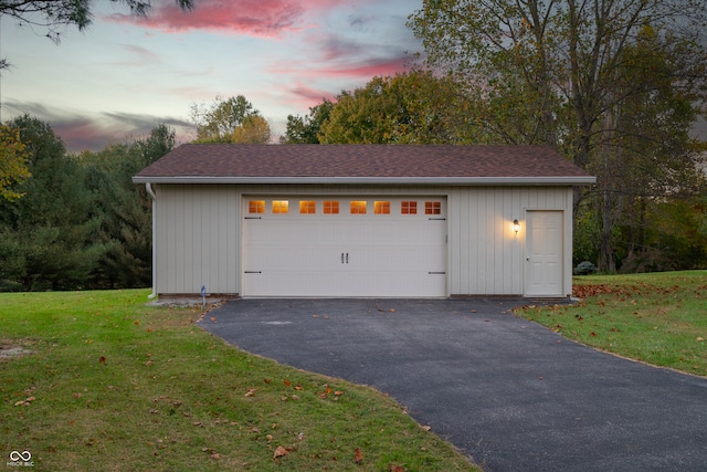 garage at dusk with a yard