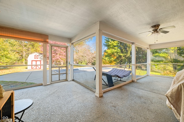 unfurnished sunroom with ceiling fan