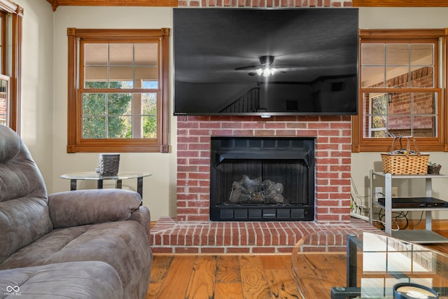 living room with hardwood / wood-style flooring and a brick fireplace