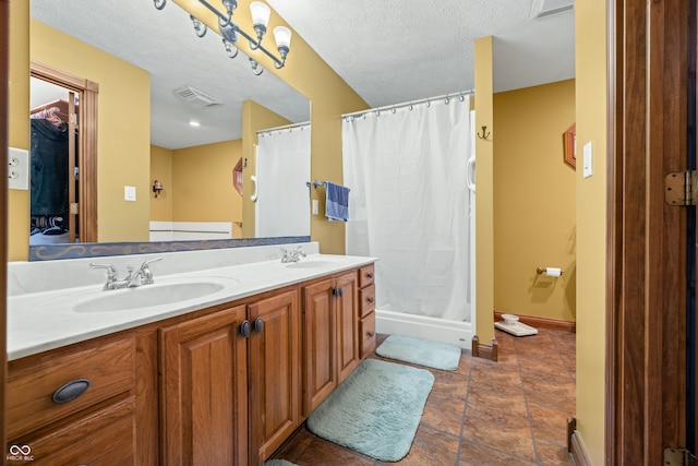 bathroom with vanity, a textured ceiling, and walk in shower