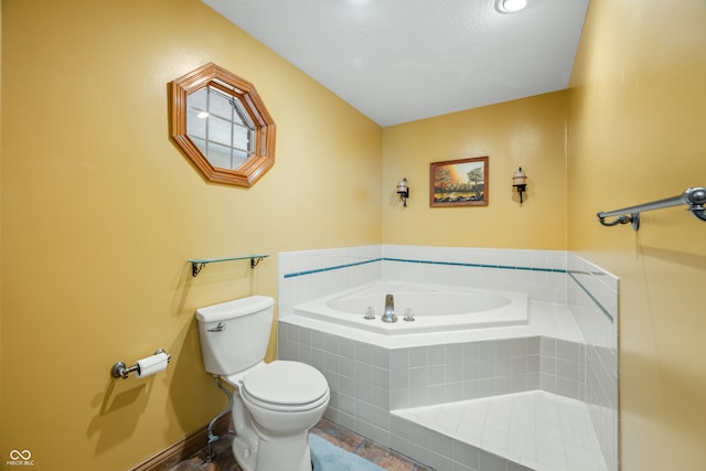 bathroom featuring tile patterned floors, a textured ceiling, tiled tub, and toilet