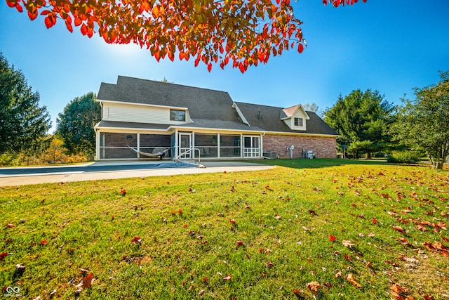 back of house with a yard, a patio, and a sunroom