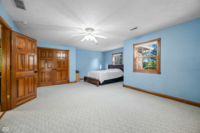 bedroom featuring carpet, a textured ceiling, and ceiling fan