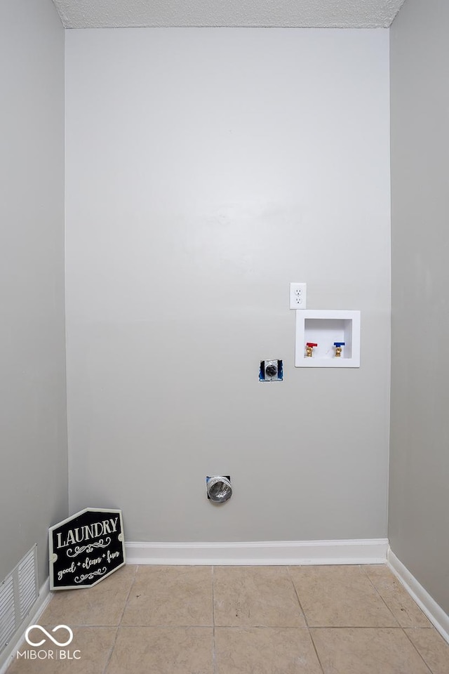 washroom with hookup for a washing machine, hookup for an electric dryer, and light tile patterned flooring