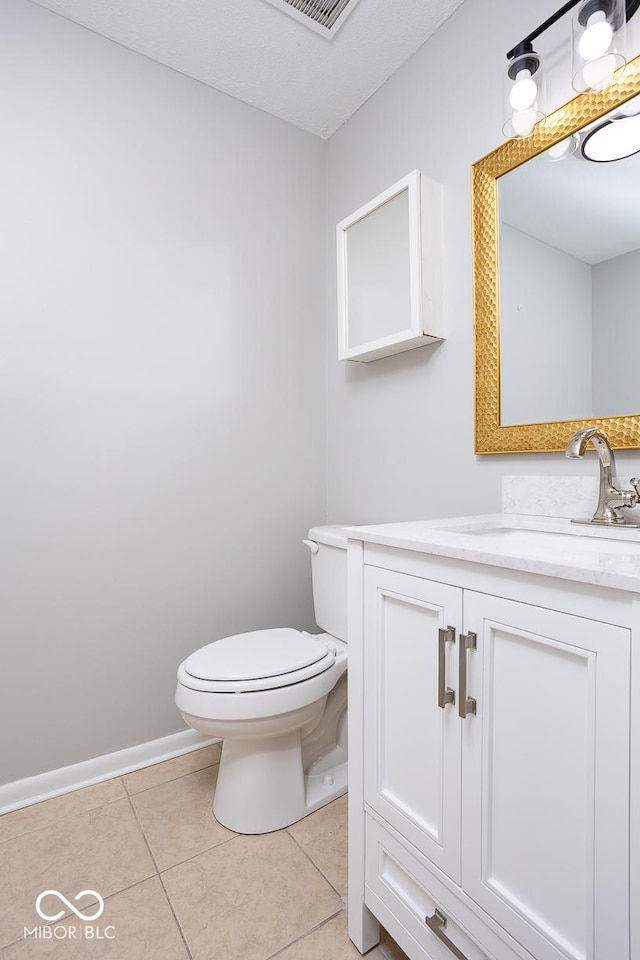 bathroom featuring vanity, tile patterned floors, and toilet