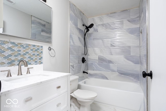 full bathroom with decorative backsplash, tiled shower / bath, vanity, and toilet