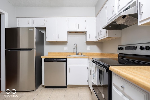 kitchen with sink, light tile patterned floors, white cabinetry, stainless steel appliances, and a textured ceiling