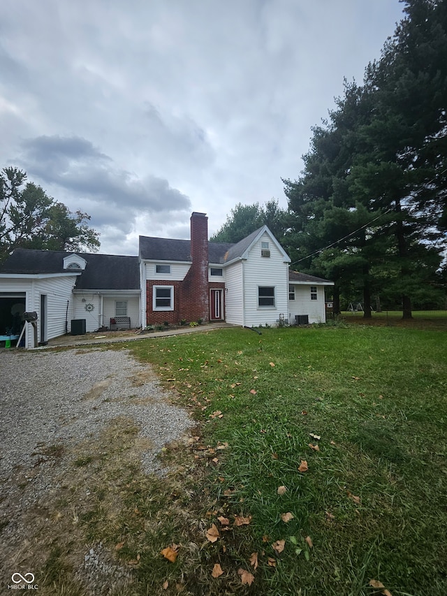 view of front of property featuring a front yard and cooling unit