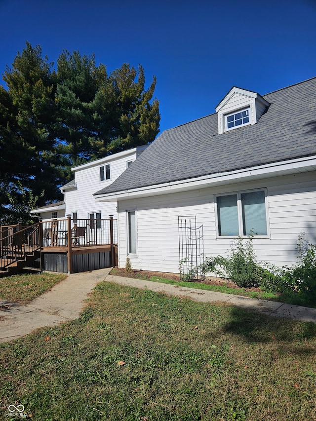 rear view of property with a deck and a lawn