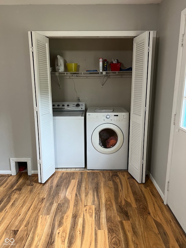 laundry room with separate washer and dryer and hardwood / wood-style floors