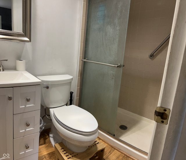 bathroom with vanity, walk in shower, toilet, and wood-type flooring