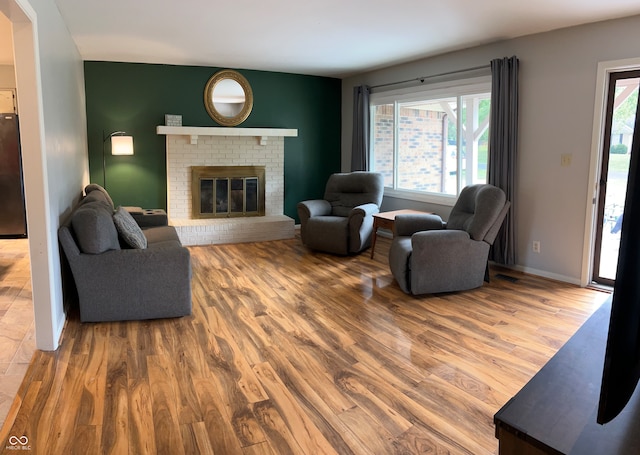 living room featuring a brick fireplace and hardwood / wood-style floors