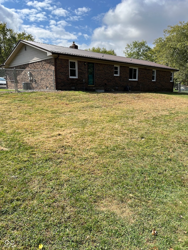 rear view of house featuring a yard