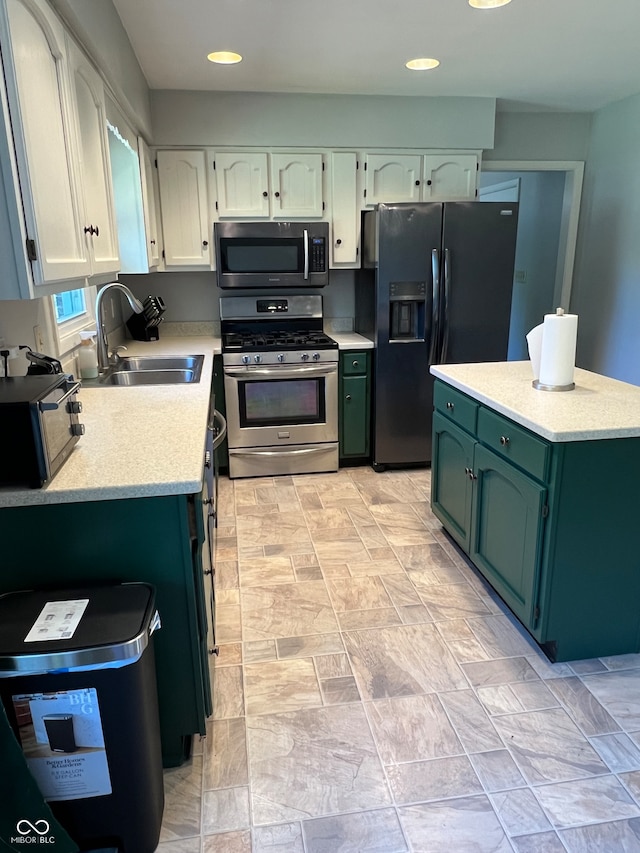 kitchen with green cabinets, black appliances, sink, and white cabinetry