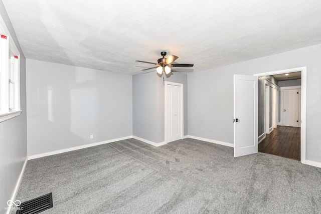 carpeted empty room featuring ceiling fan and a textured ceiling