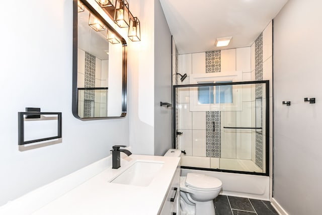 full bathroom featuring tile patterned floors, toilet, combined bath / shower with glass door, and vanity