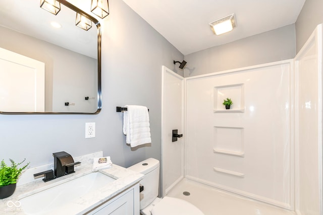 bathroom featuring toilet, vanity, and walk in shower