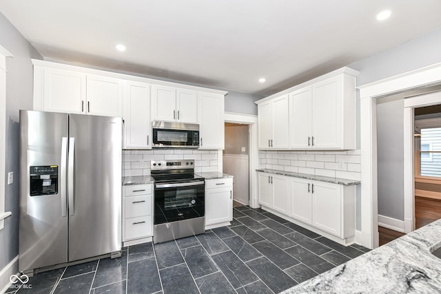 kitchen featuring decorative backsplash, light stone counters, white cabinetry, and stainless steel appliances