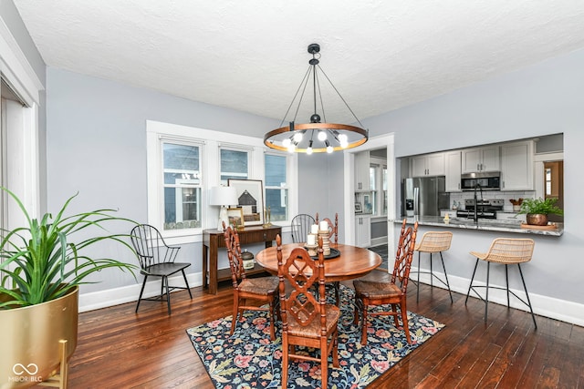 dining space with a textured ceiling and dark wood-type flooring