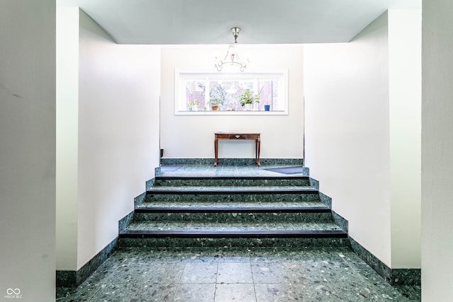 stairway featuring an inviting chandelier