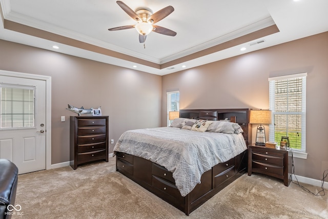 bedroom featuring multiple windows, ceiling fan, light colored carpet, and a raised ceiling