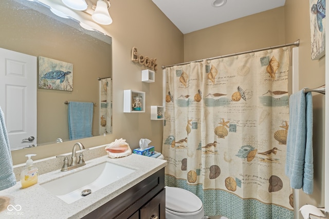 bathroom featuring vanity, toilet, and walk in shower